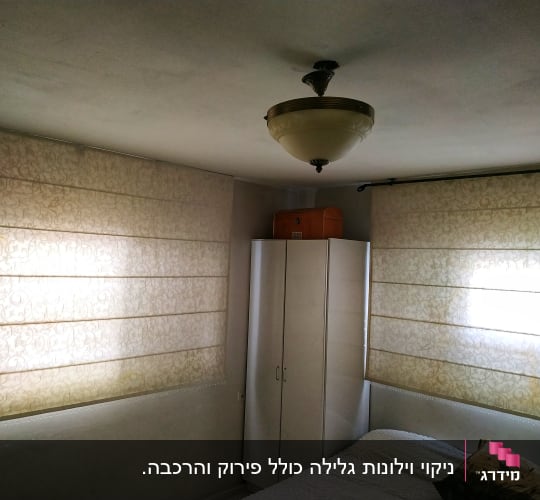 Two beige Roman blinds with floral patterns covering windows in a room.